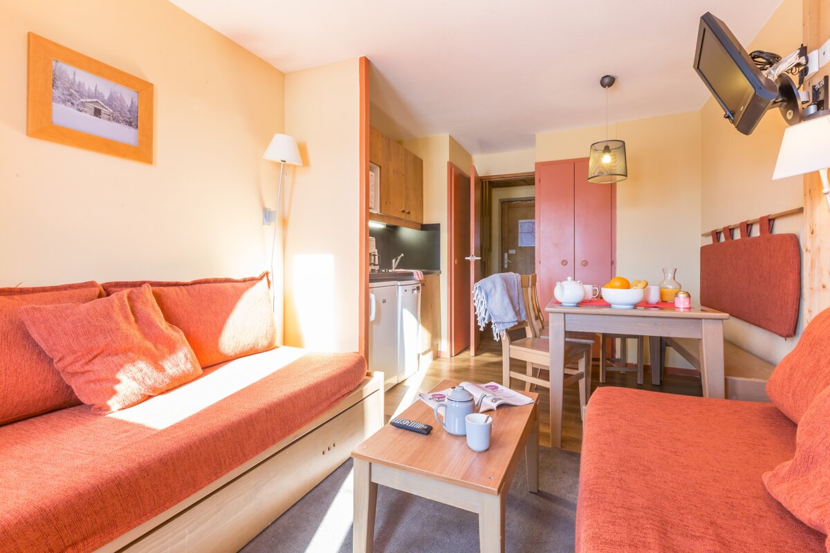 A living room with a couch a table and a television