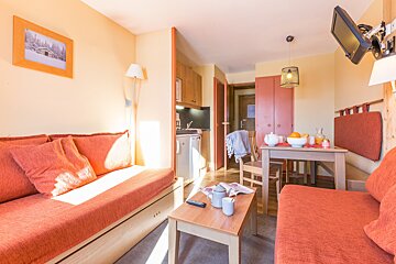 A living room with a couch a table and a television