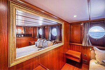 A bedroom on a boat with a large mirror on the wall