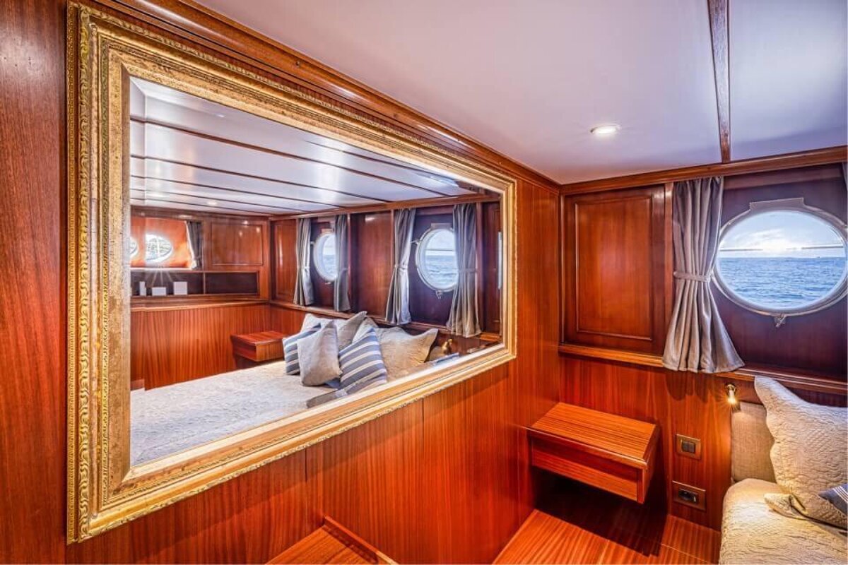 A bedroom on a boat with a large mirror on the wall