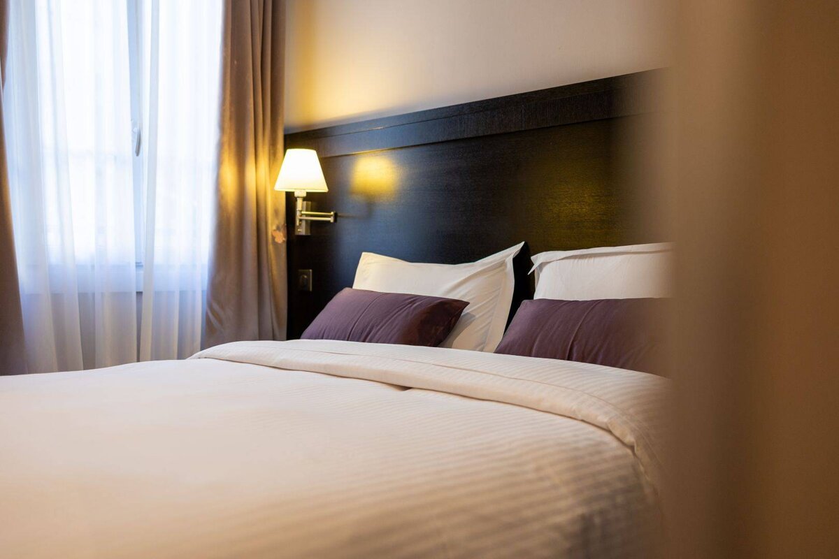 A hotel room with a bed and a window