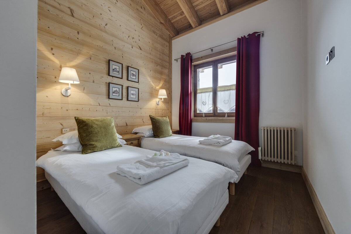 A bedroom with two twin beds and a window