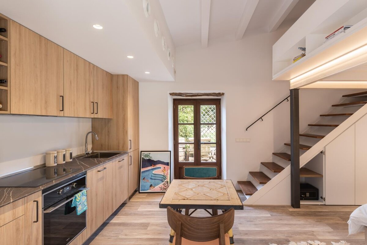 A kitchen with a table and chairs and stairs