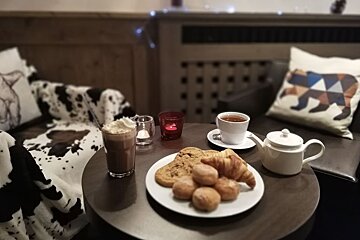 A table with a plate of cookies and a cup of tea