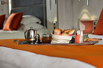 A bed with a tray of food and drinks on it