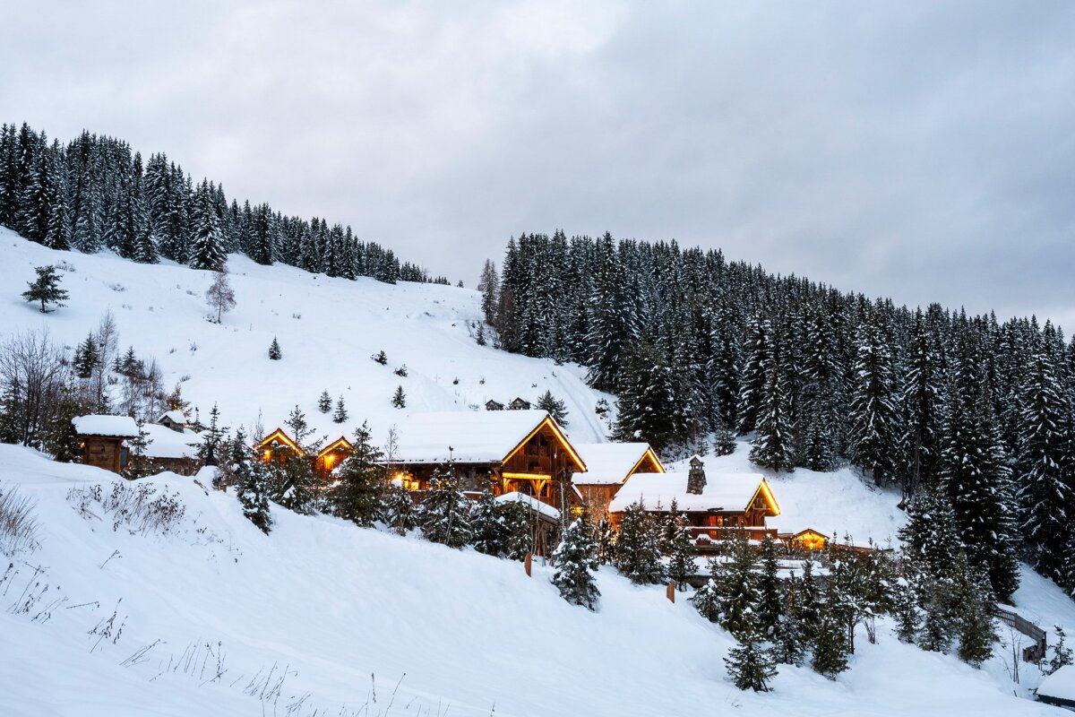 A snowy landscape with a cabin in the foreground