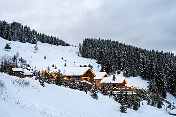 A snowy landscape with a cabin in the foreground