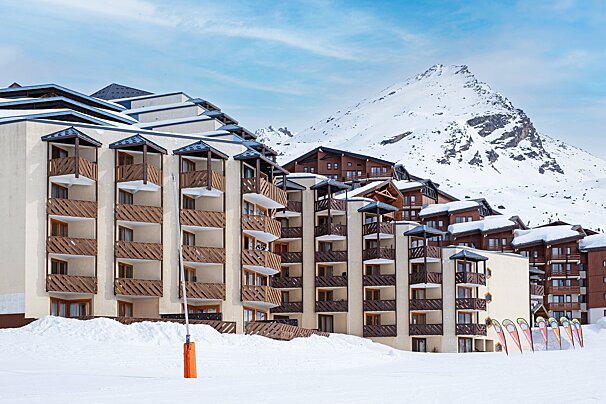 A building with a mountain in the background is covered in snow