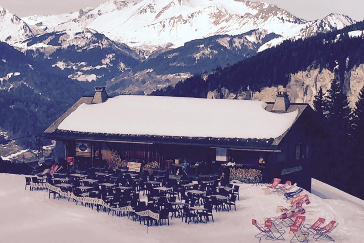 A snowy mountain with a restaurant in the foreground