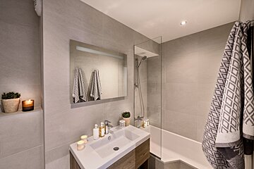 A bathroom with a sink a bathtub and a mirror