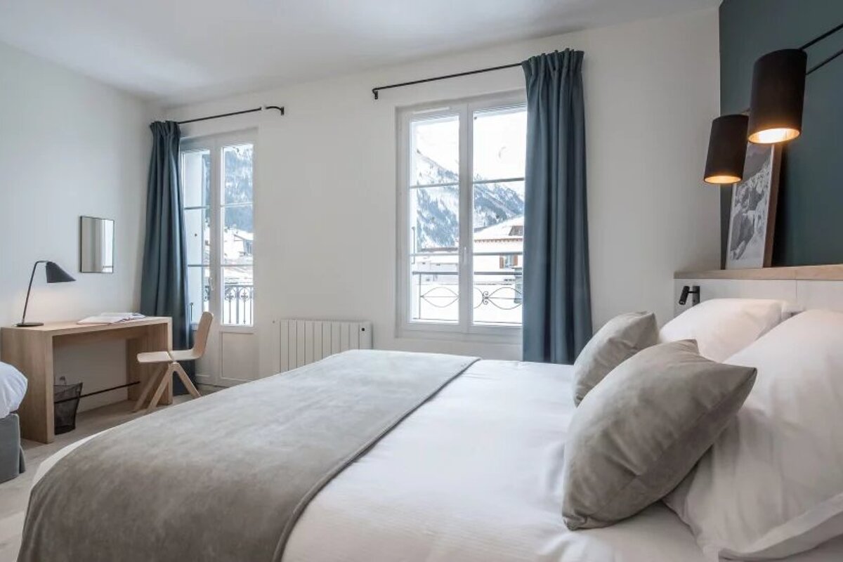 A bedroom with a large bed and a desk