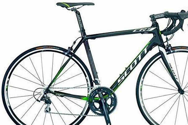 A black and green bicycle is sitting on a white surface