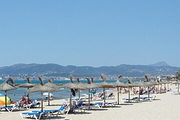 a beach in Mallorca with sea grass parasols