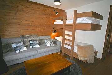 A living room with a couch and bunk beds