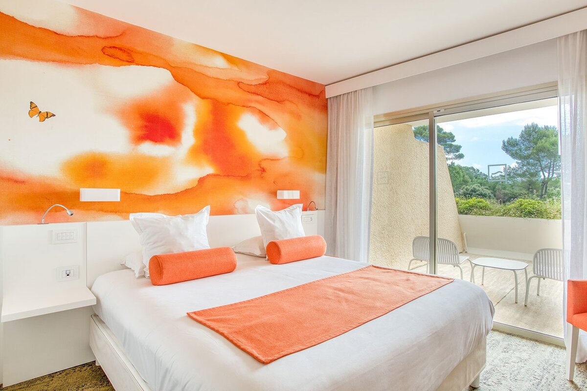 A hotel room with a bed and a butterfly on the wall