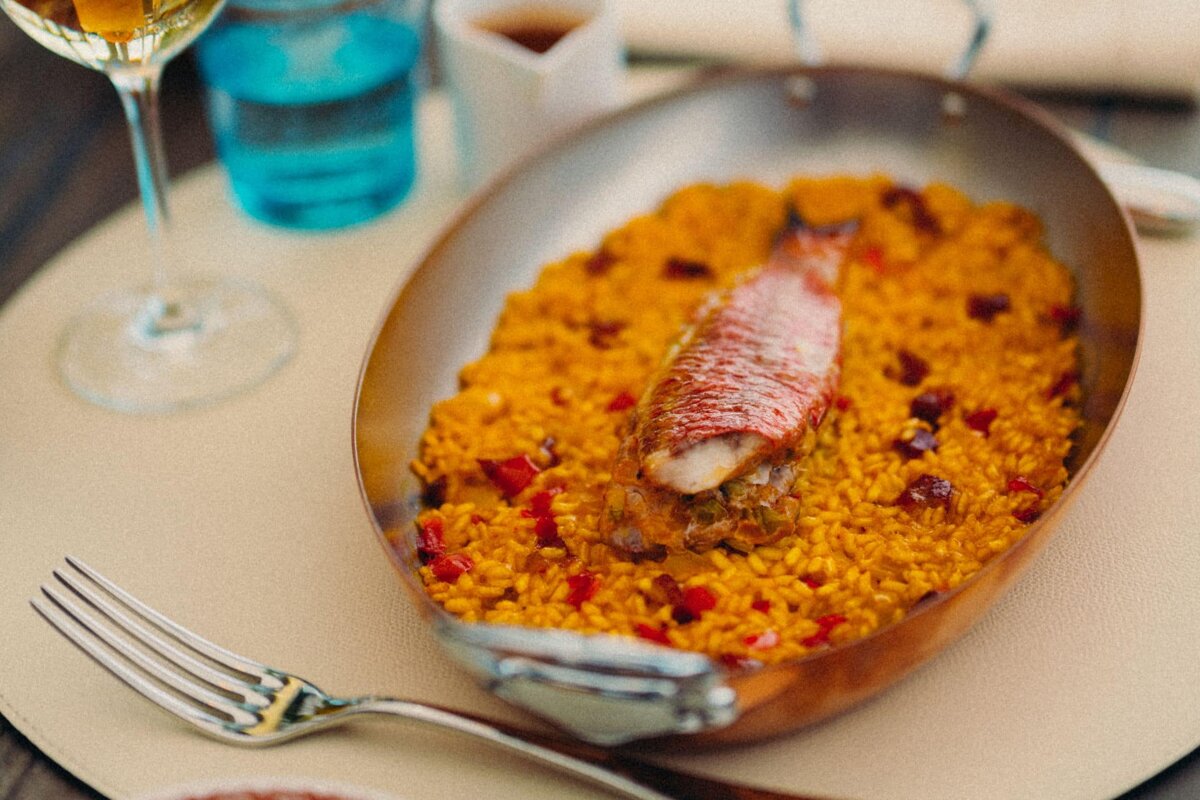 A pan of rice with a piece of fish on top