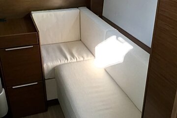 A white couch sits next to a wooden cabinet