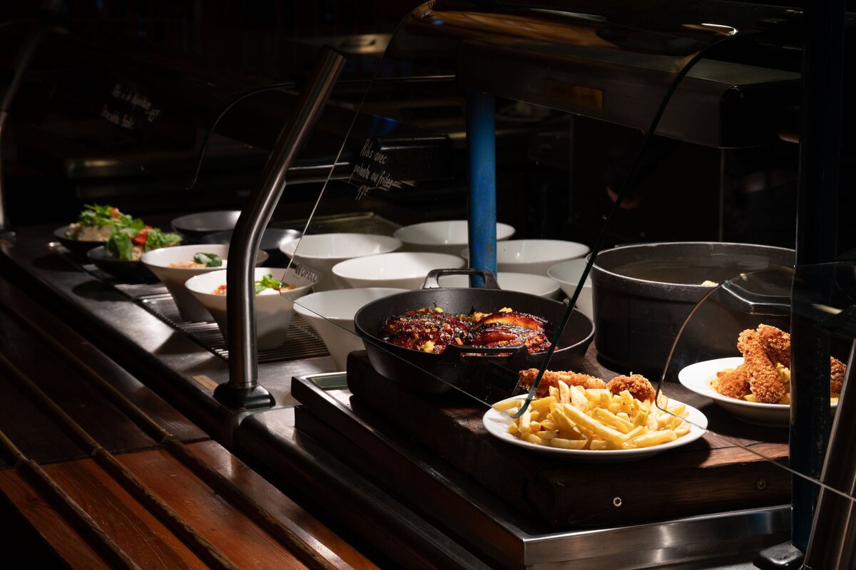 A buffet line with a sign that says ' french fries ' on it