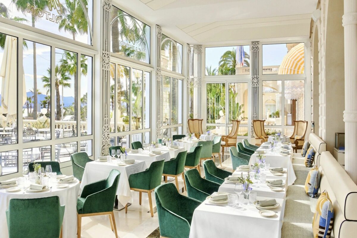 A dining room with tables and chairs and the word hotel on the wall