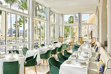 A dining room with tables and chairs and the word hotel on the wall