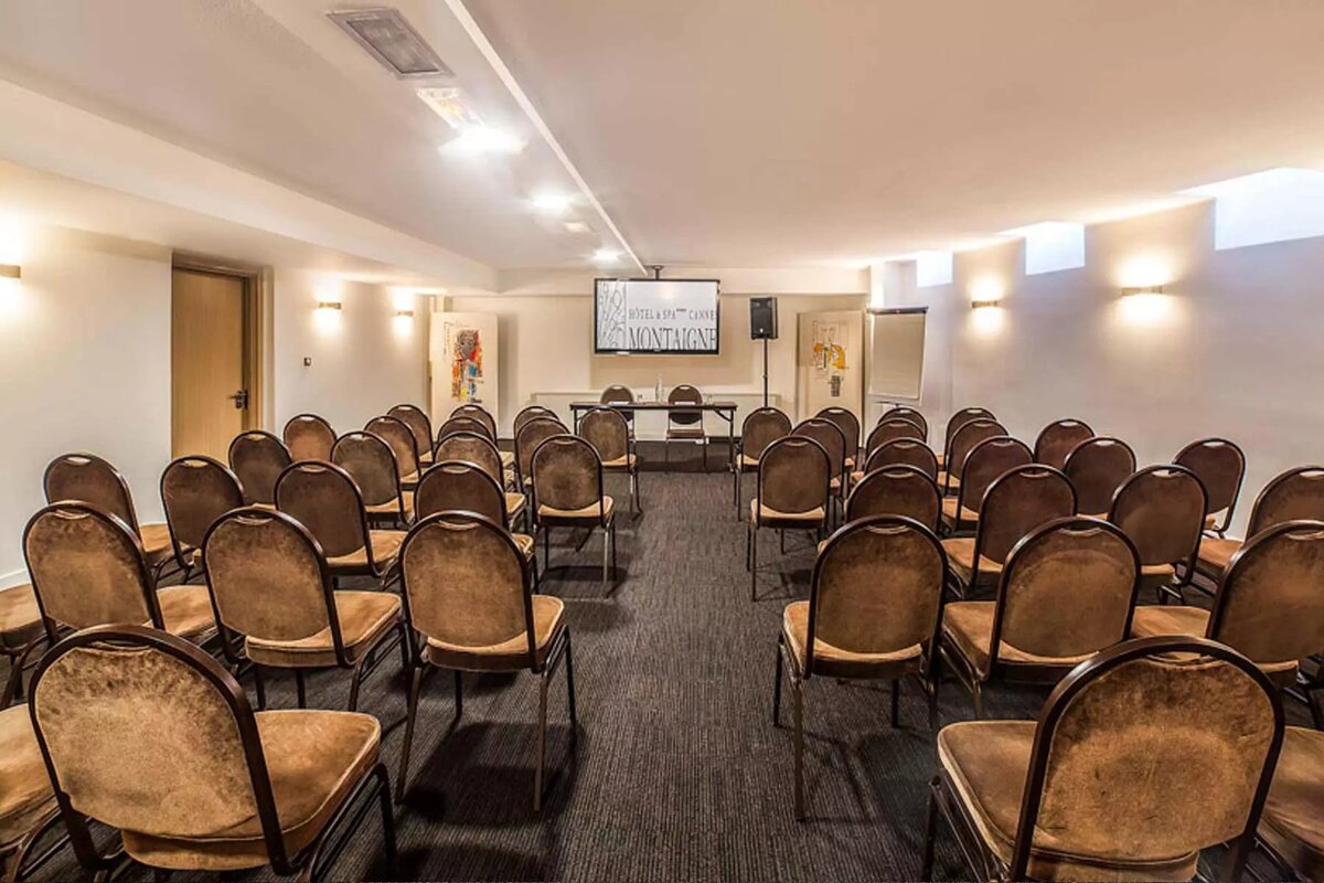 A conference room with rows of chairs and a projector screen that says montevideo