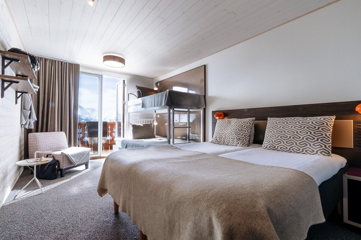 A hotel room with two beds and a bunk bed