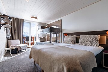 A hotel room with two beds and a bunk bed