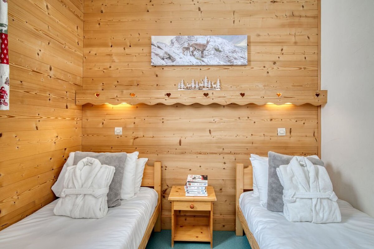 A bedroom with two beds and a painting on the wall