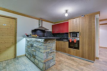 A kitchen with wooden cabinets and a microwave oven