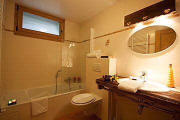 A bathroom with a toilet a sink and a window