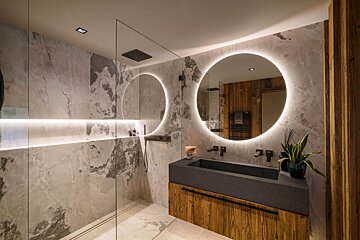 A bathroom with two round mirrors and a sink
