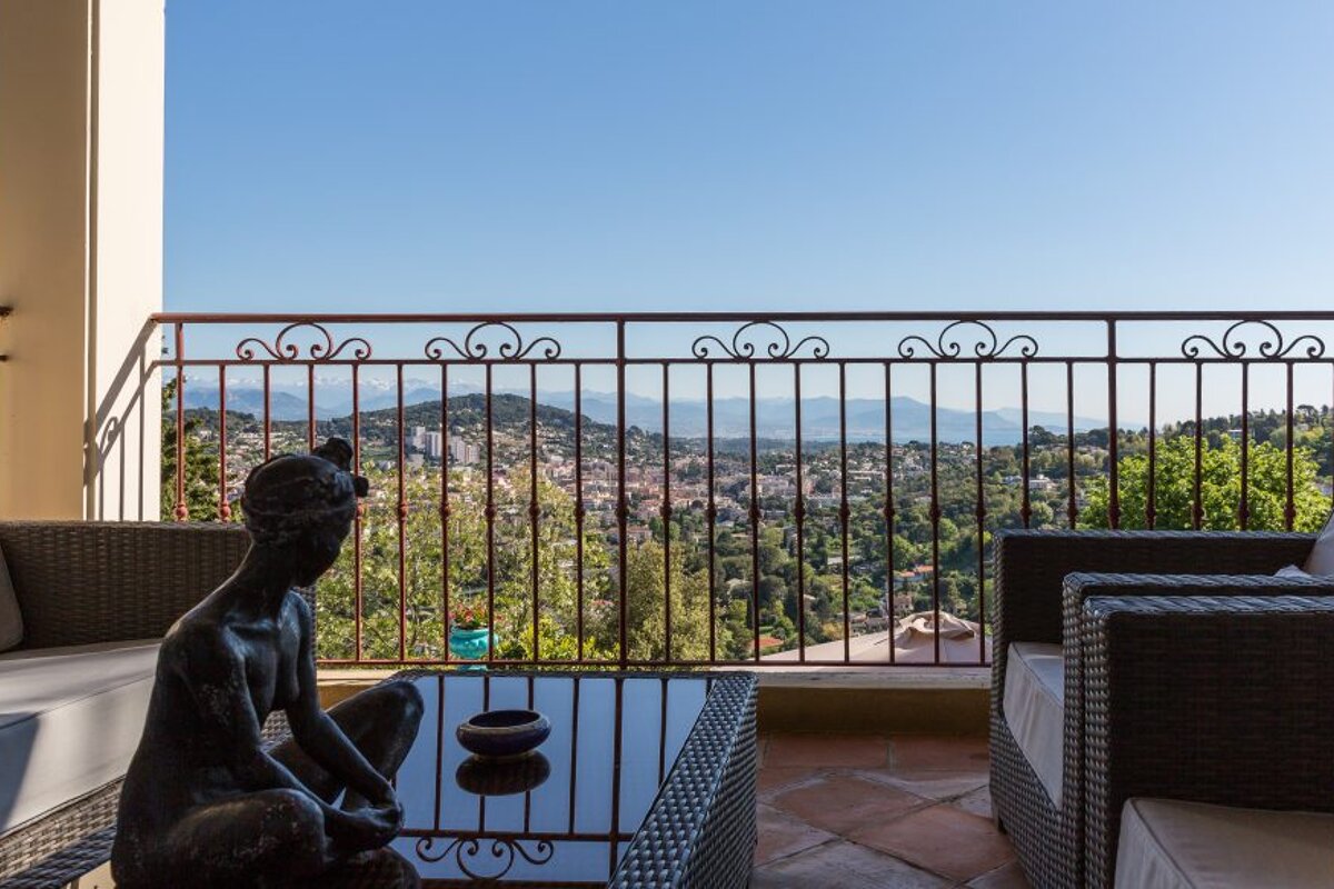 A balcony with a view of a city and mountains