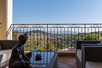 A balcony with a view of a city and mountains