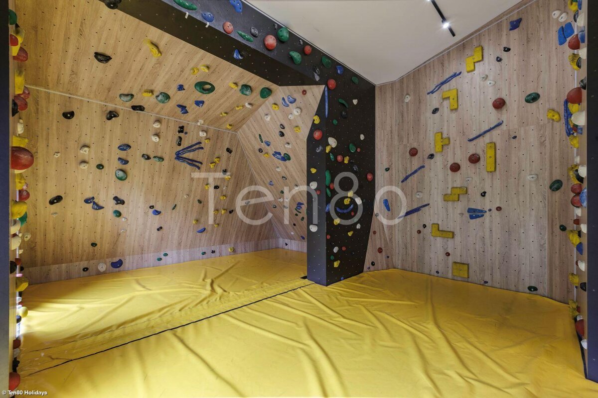 A room with a climbing wall and the word tengo on the wall