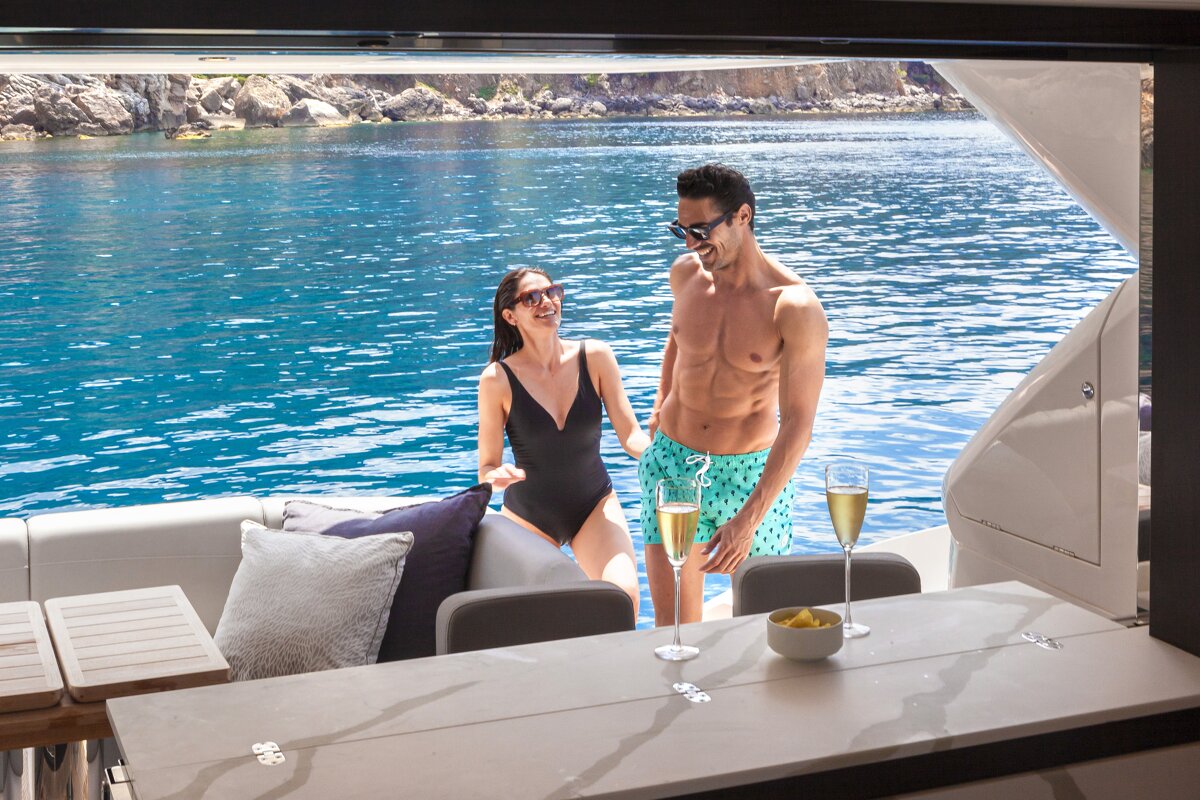 A man and a woman standing on a boat drinking champagne