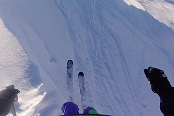 a skier dropping into a bowl in tignes