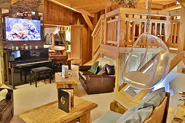 A living room with a piano and a hanging chair