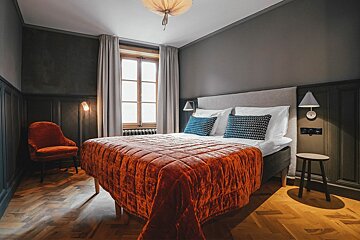 A hotel room with a bed and a chair