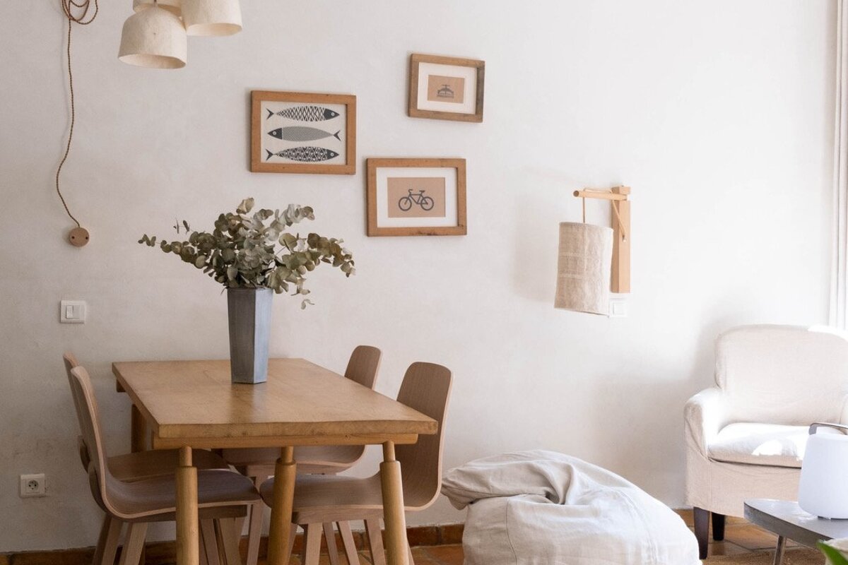 A dining room with a table and chairs and pictures on the wall
