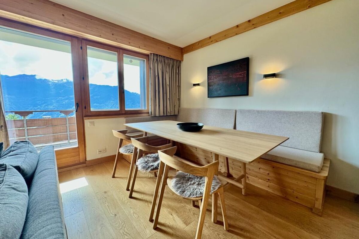 A living room with a wooden table and chairs