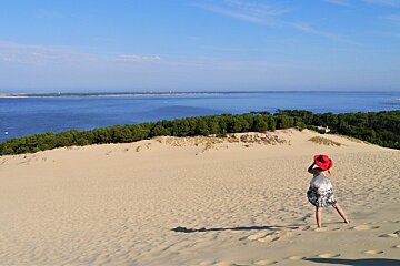 a woman with a red hat on the dune du pilat