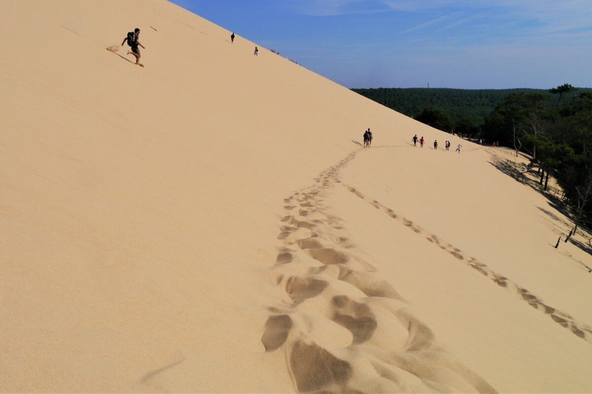 footprints & man running down the sand dune