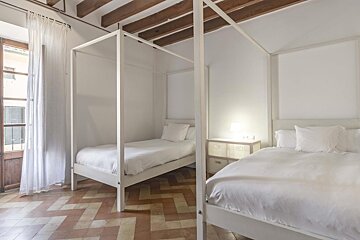 A bedroom with two beds and a canopy bed