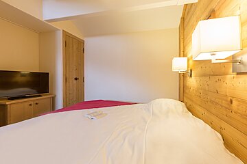 A bedroom with a bed and a flat screen tv