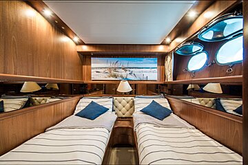 A bedroom with two beds and a painting on the wall