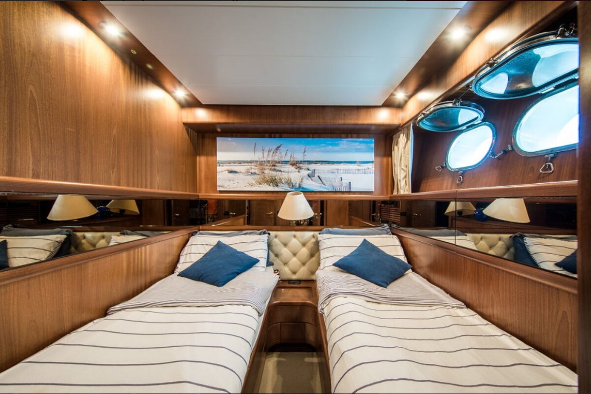 A bedroom with two beds and a painting on the wall