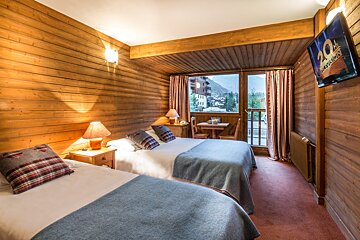 A hotel room with two beds and a television that says tokyo 2020