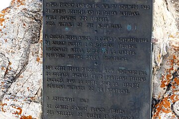 a metal sign on a rock