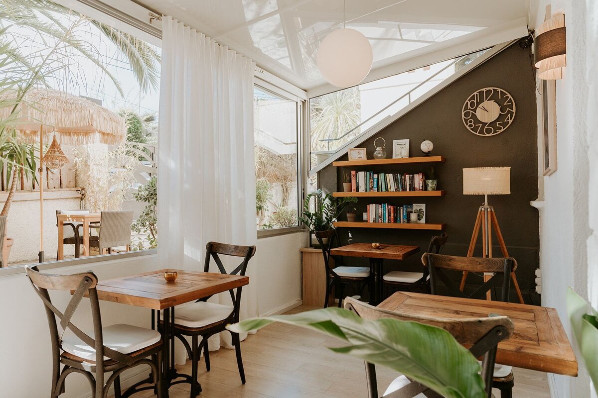 A room with tables and chairs and a clock on the wall that shows the time as 6:54