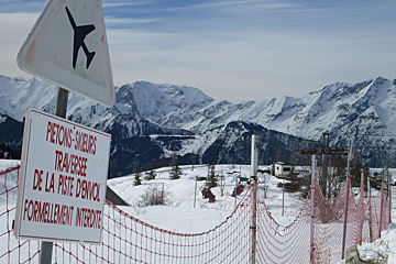 a sign by a fence warning of planes